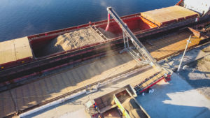 Aerial view of big grain elevators on the sea. Loading of grain on ship. Port Ukraine. Cargo ship