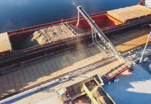 Aerial view of big grain elevators on the sea. Loading of grain on ship. Port Ukraine. Cargo ship