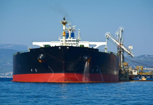 Oil tanker bringing its cargo in a tank storage facility.