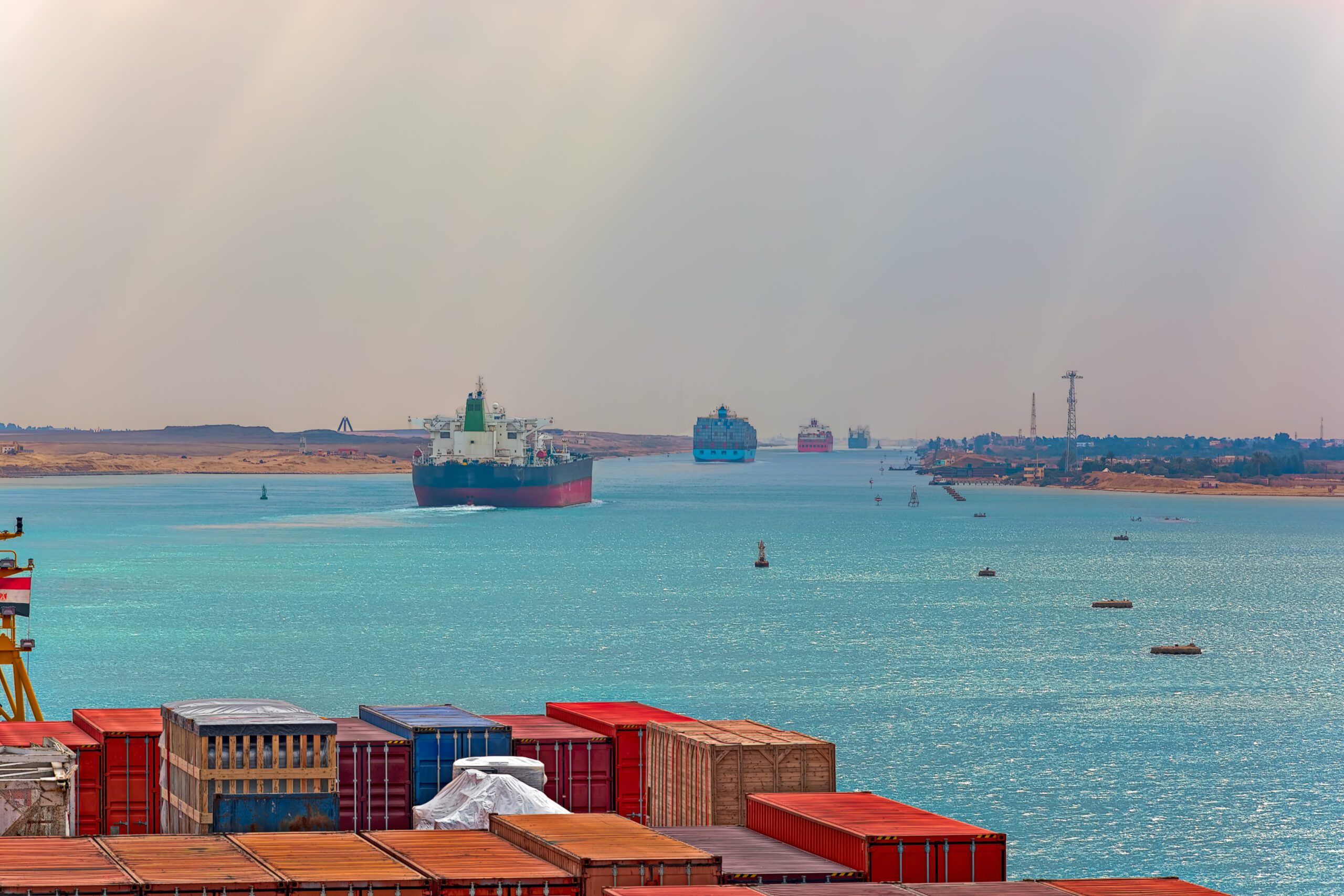 Industrial container ship passing through Suez Canal with ships convoy, view on the bow from the captain bridge.