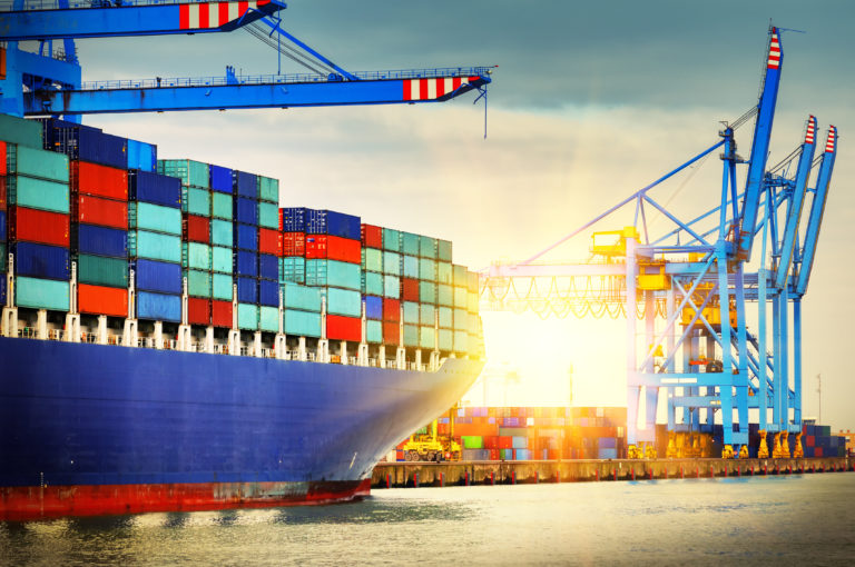 Container ship with full of cargo entering a port.