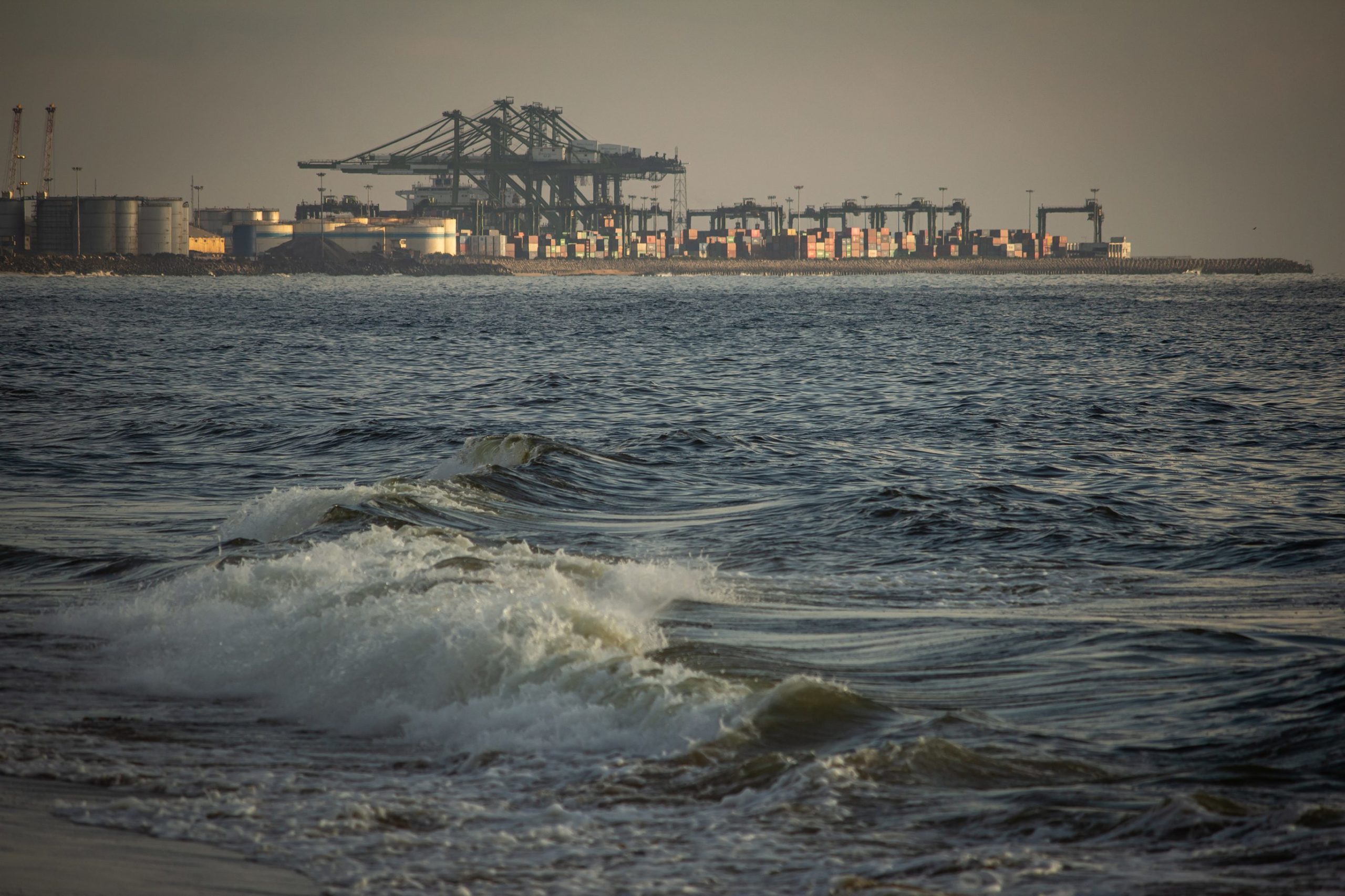 Scenic view of the waves of the Bay of Bengal along Marina Beach with port in background, Chennai, India.