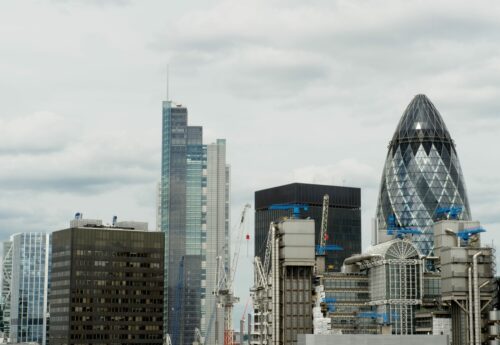 Cloudy or stormy skies over the City of London as seen from the top of the Monument to the Great Fire of London. The image shows 30 St Mary Axe (formerly Swiss Re Building and aka the Gherkin) designed by Norman Foster and Arup engineers and erected by Skanska on the site of the former Baltic Exchange in 2001â€“2003, Lloyd s of London (a British insurance and reinsurance market) and other building