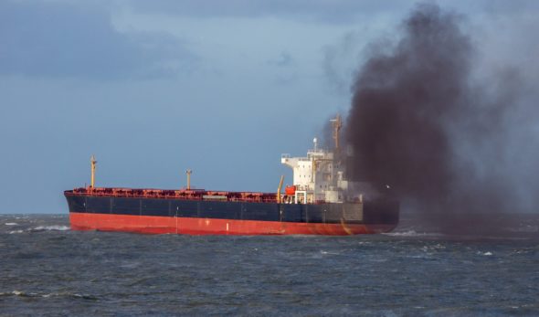 Industrial cargo ship causing air pollution leaving the Port of Rotterdam.
