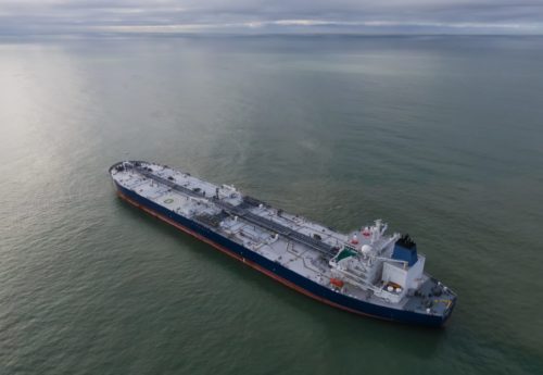 Aerial drone photo from drone of a suezmax tanker at anchor in cloudy weather.