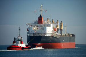 A supramax bulker in ballast is assisted by a tug boat in the Port of Los Angeles.