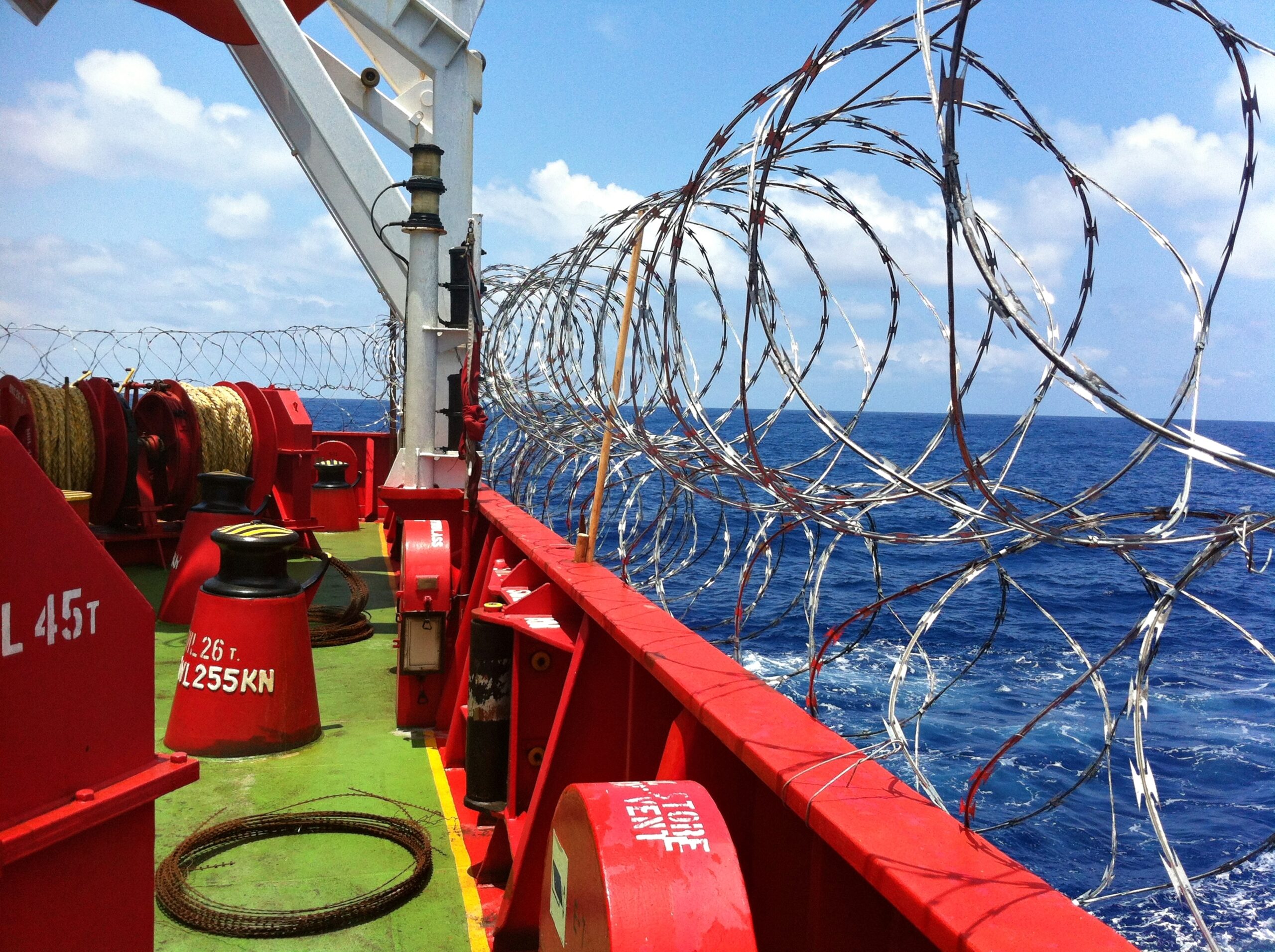 Barbed wire is twisted on board the tanker to protect against pirate attacks