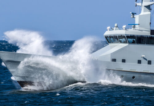 Danish coast guard ship breaking through rough waves