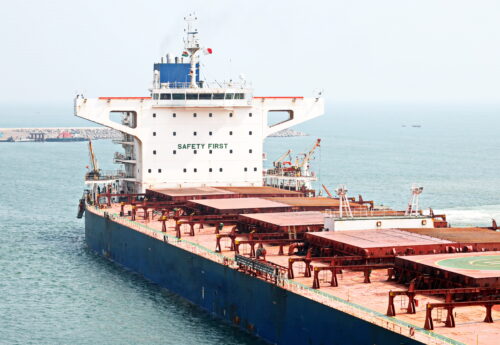 A large bulk carriers, tugboats at the port under cargo operations and underway.