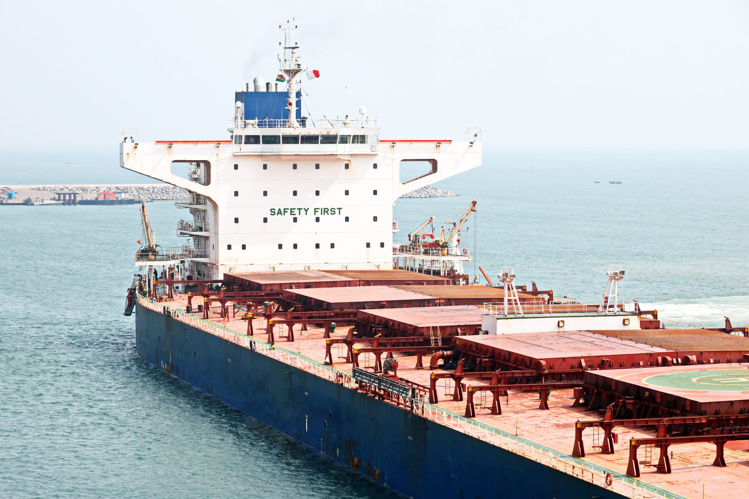 A large bulk carriers, tugboats at the port under cargo operations and underway.