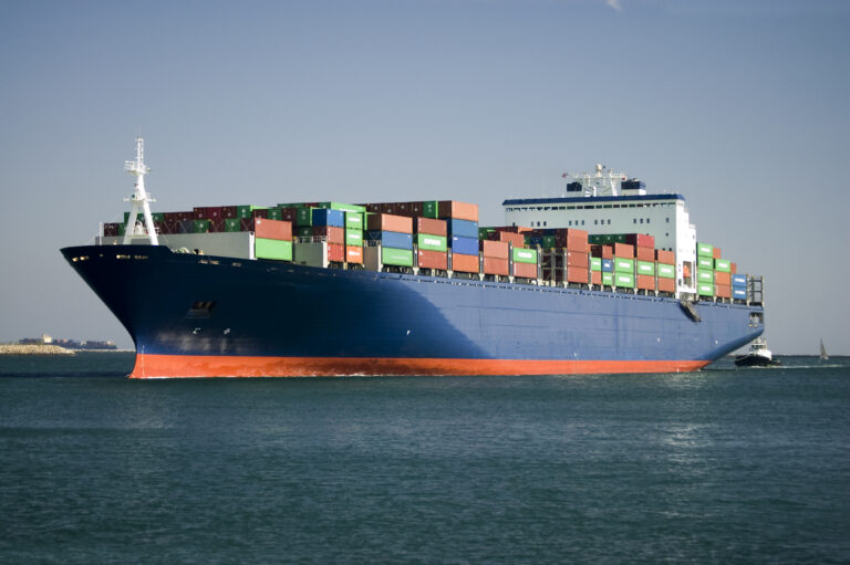 Ocean going container liner ship as it moves down a channel and enters the harbor.