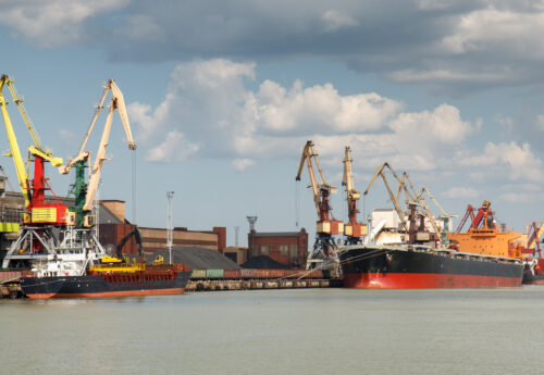 Industrial harbor with two freight ships with coal being loaded in.