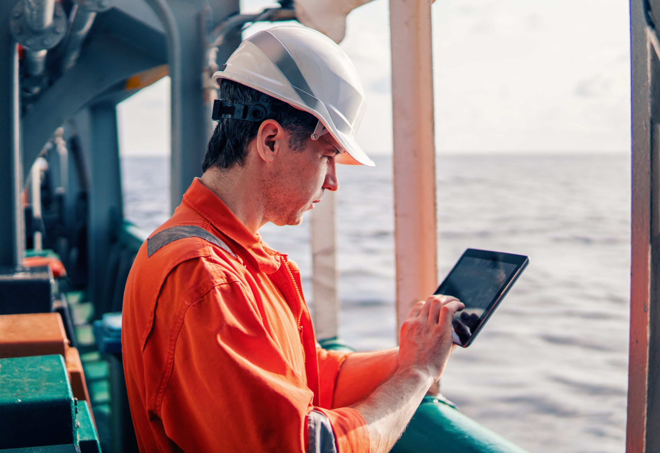 Chief officer or captain on deck of vessel or ship watching digital tablet