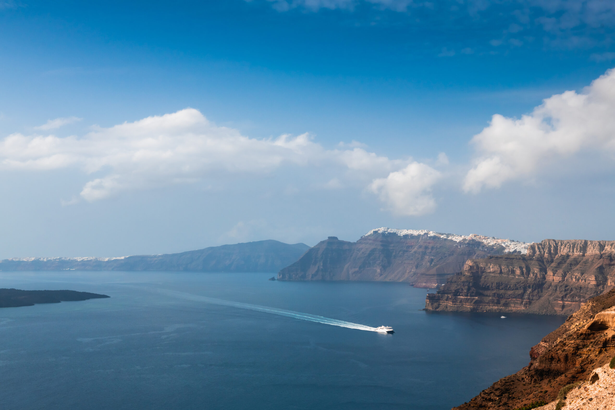 Panoramic view over Santorini Island with a ferry