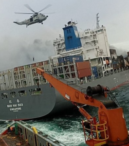 Fire-stricken Wan Hai 503 boxship under tow by salvage tugs.
